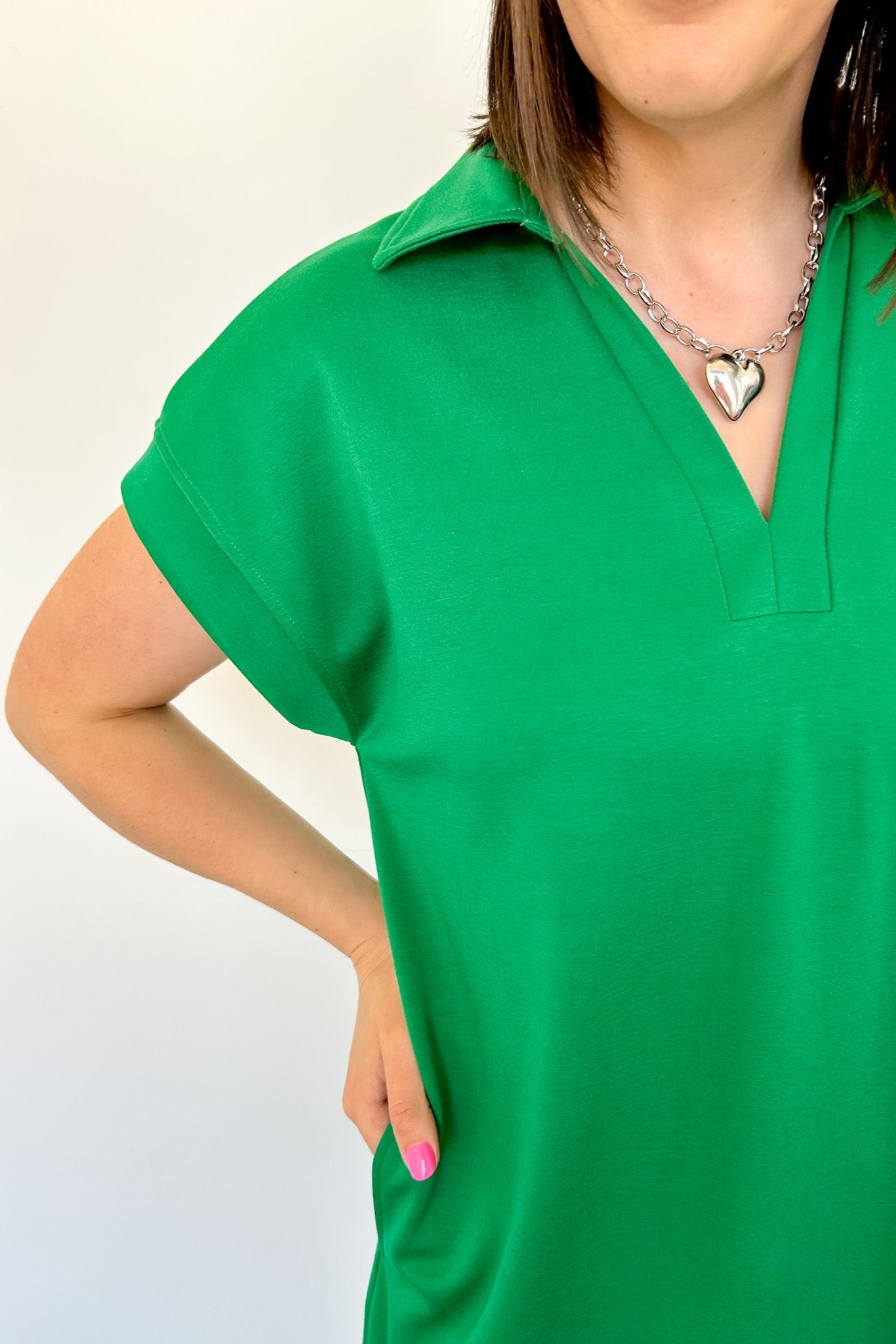 Athleisure dress that hits above the knees. Collared and short sleeve. Features a v neckline and pockets.  Emerald in color.