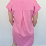 Athleisure dress that hits above the knees. Collared and short sleeve. Features a v neckline and pockets. Pink in color.