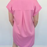 Athleisure dress that hits above the knees. Collared and short sleeve. Features a v neckline and pockets. Pink in color.