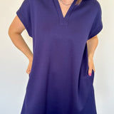 Athleisure dress that hits above the knees. Collared and short sleeve. Features a v neckline and pockets.  Navy in color.
