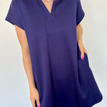 Athleisure dress that hits above the knees. Collared and short sleeve. Features a v neckline and pockets.  Navy in color.