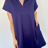 Athleisure dress that hits above the knees. Collared and short sleeve. Features a v neckline and pockets.  Navy in color.