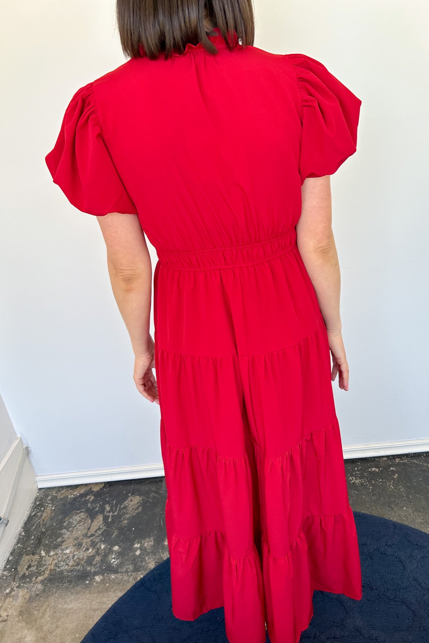 Maxi length dress with v neckline. Short sleeve with slightly bubbled sleeves. Tiered bottom. Elastic waist. Red in color.