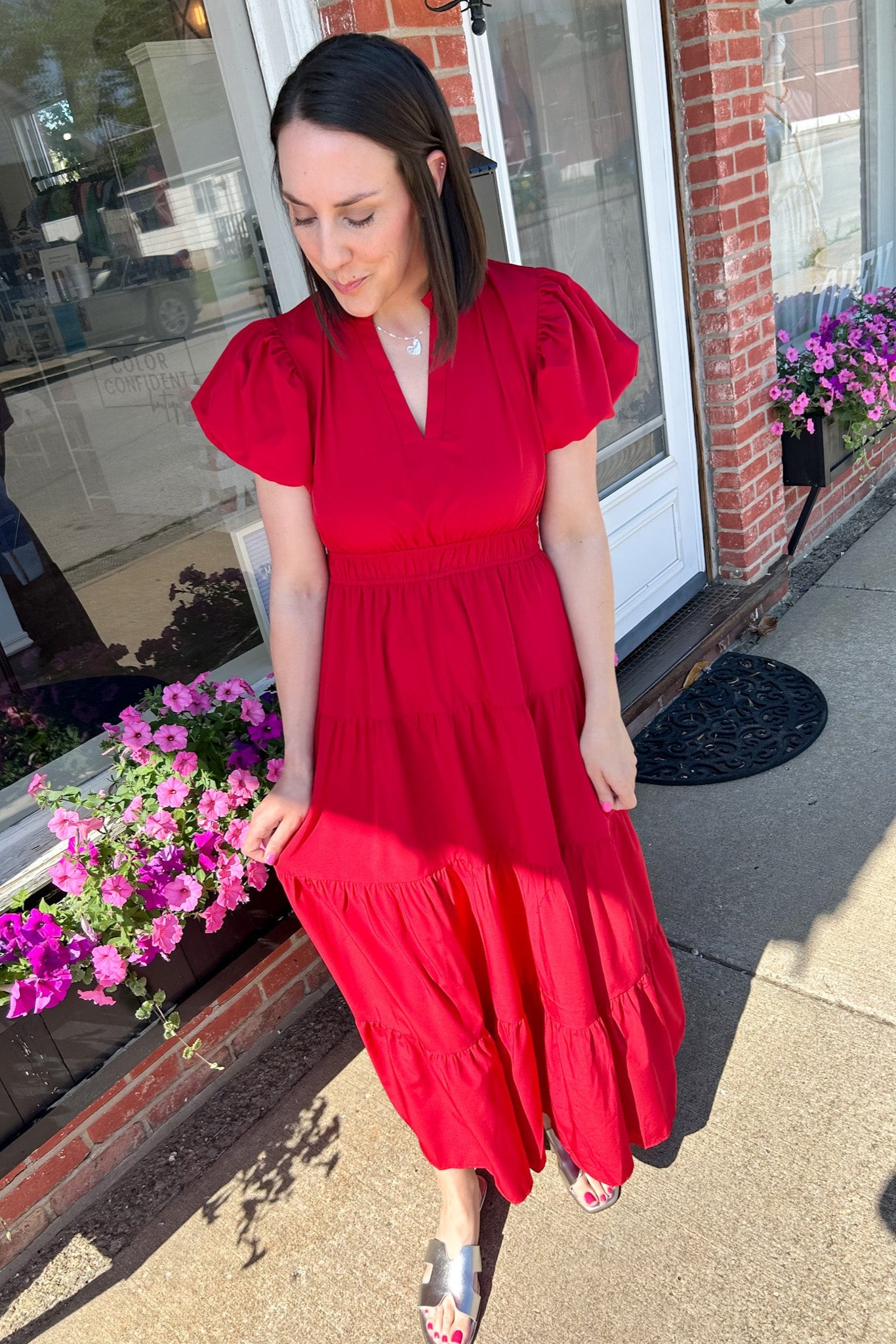 Maxi length dress with v neckline. Short sleeve with slightly bubbled sleeves. Tiered bottom. Elastic waist. Red in color.
