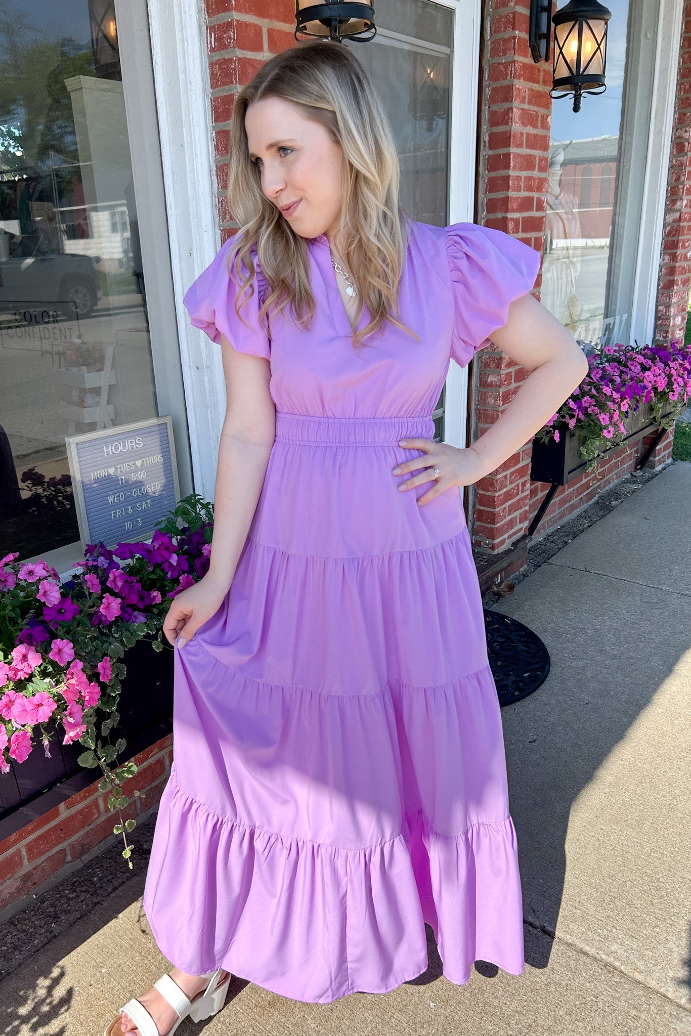 Maxi length dress with v neckline. Short sleeve with slightly bubbled sleeves. Tiered bottom. Elastic waist. Purple in color.
