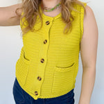Button up vest with brown buttons. Pockets in the front. Braided detail around the tank sleeves and neckline, as well as the bottom of the top. Chartreuse in color.