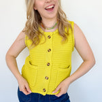 Button up vest with brown buttons. Pockets in the front. Braided detail around the tank sleeves and neckline, as well as the bottom of the top. Chartreuse in color.