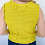 Button up vest with brown buttons. Pockets in the front. Braided detail around the tank sleeves and neckline, as well as the bottom of the top. Chartreuse in color.