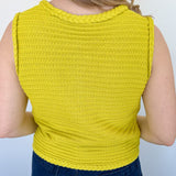 Button up vest with brown buttons. Pockets in the front. Braided detail around the tank sleeves and neckline, as well as the bottom of the top. Chartreuse in color.