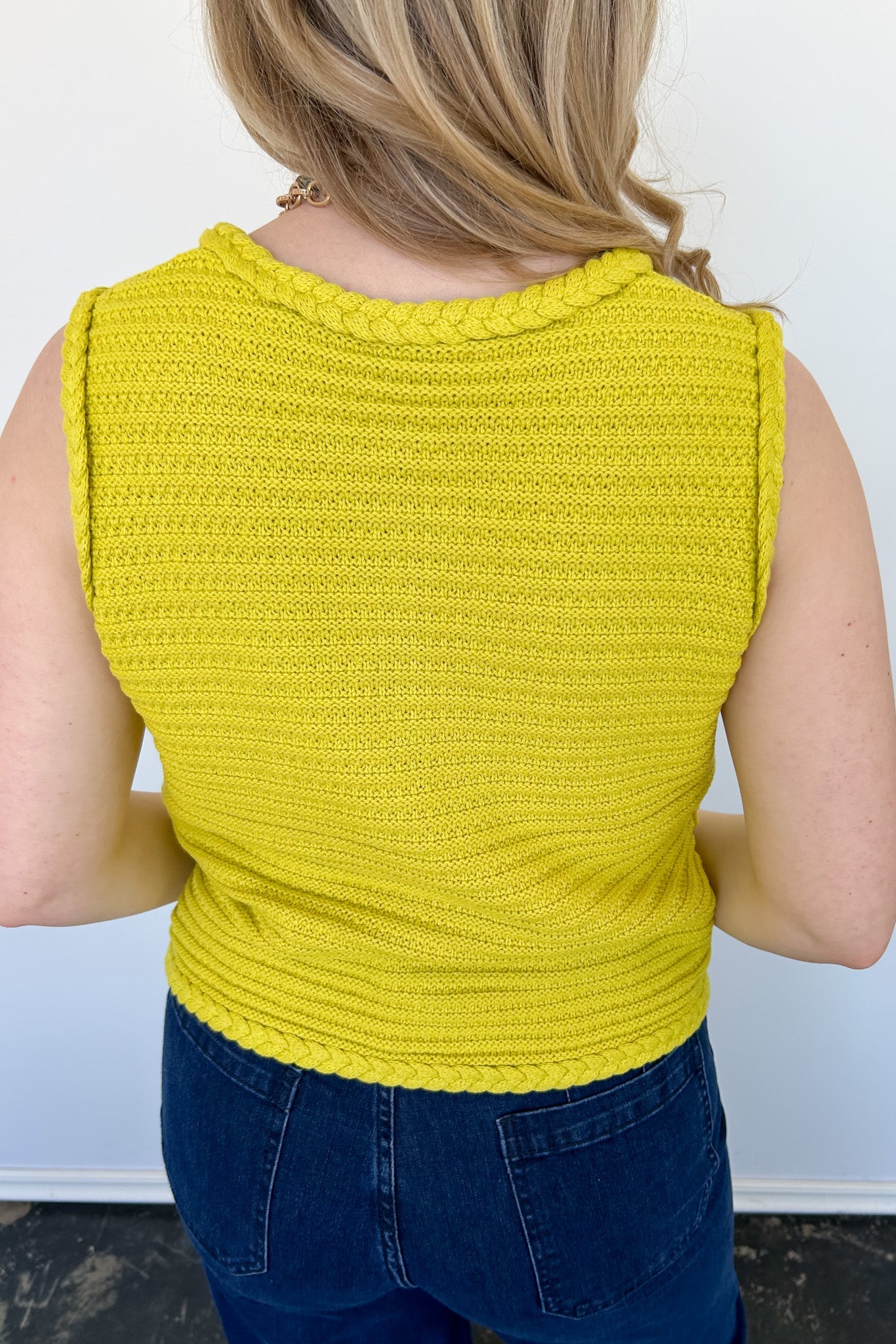 Button up vest with brown buttons. Pockets in the front. Braided detail around the tank sleeves and neckline, as well as the bottom of the top. Chartreuse in color.