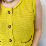 Button up vest with brown buttons. Pockets in the front. Braided detail around the tank sleeves and neckline, as well as the bottom of the top. Chartreuse in color.
