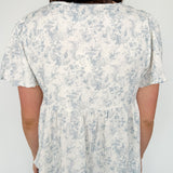 Short flowy sleeved top with button detailing. Cream in color with light blue floral pattern. Babydoll style.