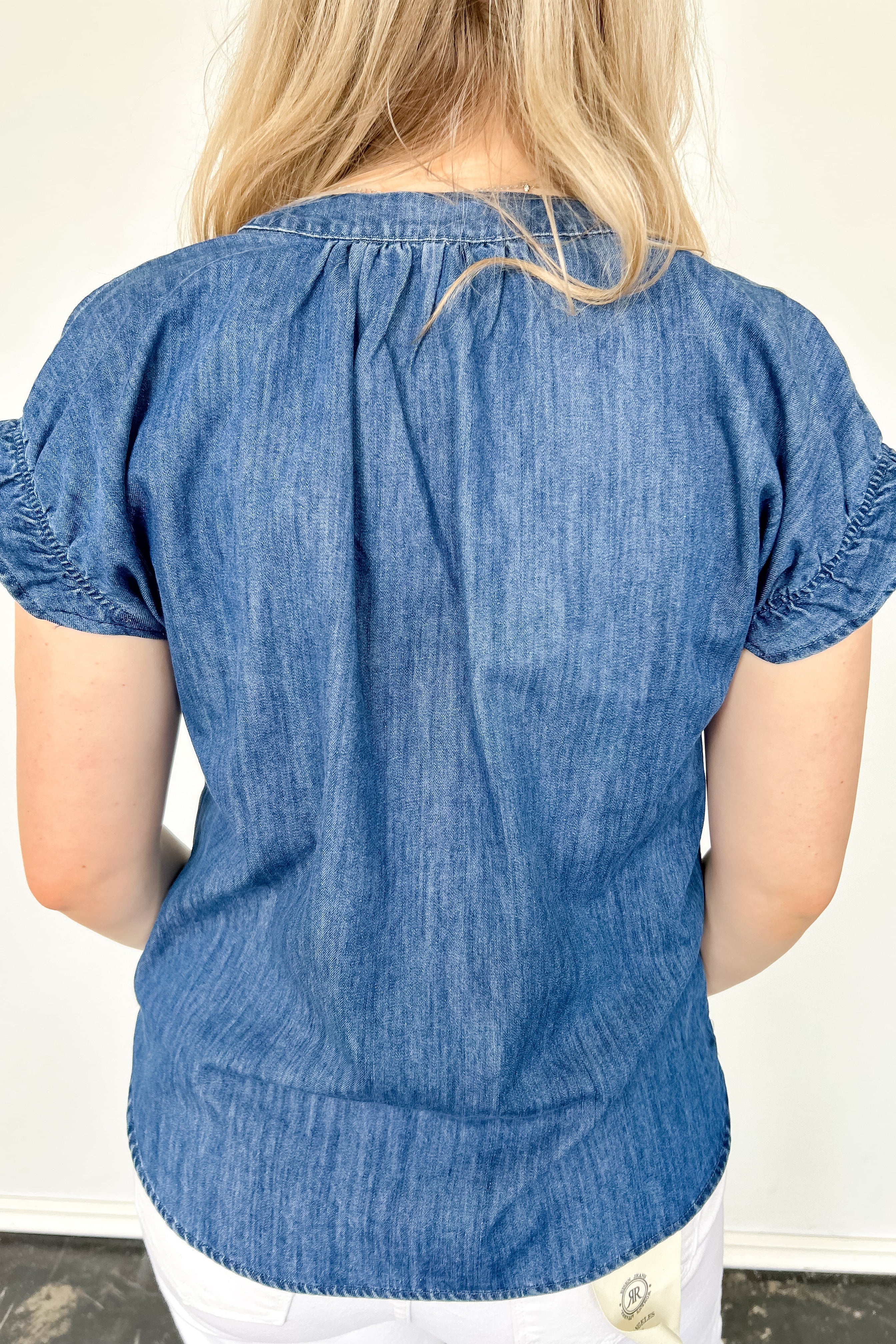 Denim top with slight v neckline and ruffled sleeves. Regular fit. Medium denim in color. Short sleeve. 