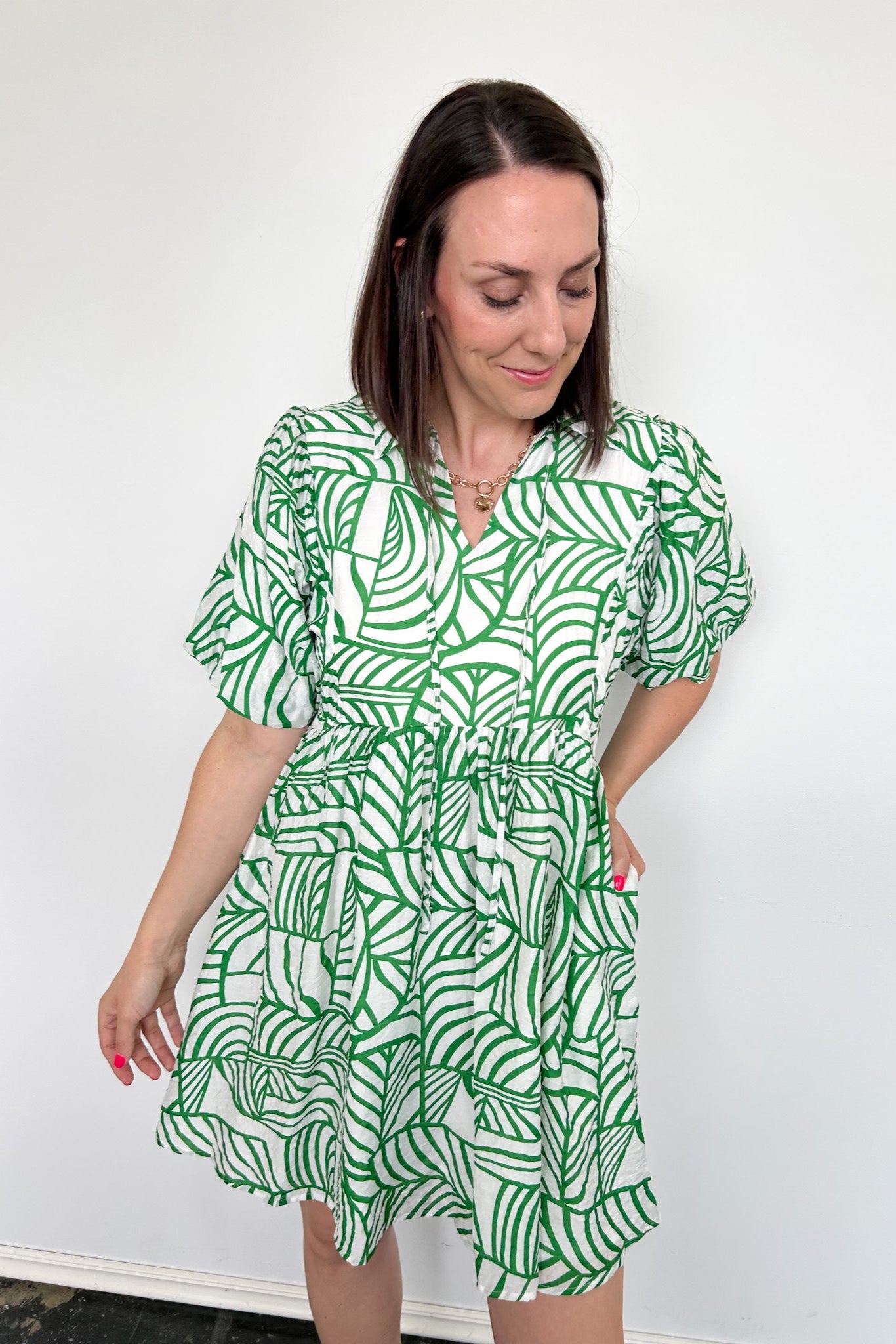 Green and white printed dress. Slight v neck. Short in length, hitting above the knee. Short sleeved.