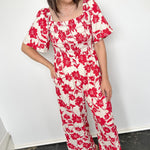 Red and white floral jumpsuit with square neckline. Short sleeved. Wide leg with smocked top. 
