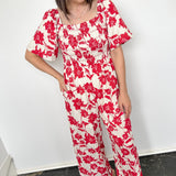 Red and white floral jumpsuit with square neckline. Short sleeved. Wide leg with smocked top. 