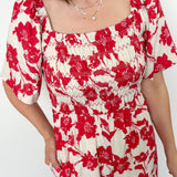 Red and white floral jumpsuit with square neckline. Short sleeved. Wide leg with smocked top. 