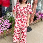 Red and white floral jumpsuit with square neckline. Short sleeved. Wide leg with smocked top. 