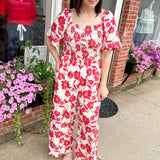 Red and white floral jumpsuit with square neckline. Short sleeved. Wide leg with smocked top. 
