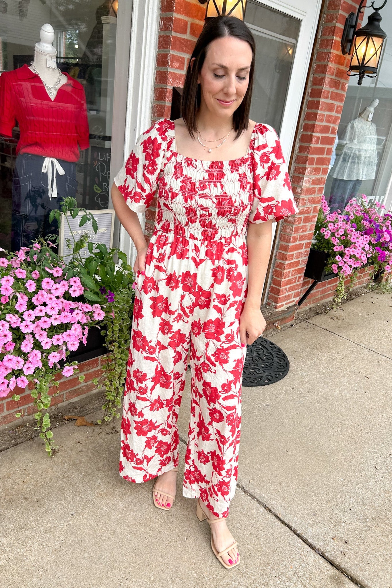 Red and white floral jumpsuit with square neckline. Short sleeved. Wide leg with smocked top. 