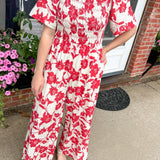 Red and white floral jumpsuit with square neckline. Short sleeved. Wide leg with smocked top. 