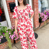 Red and white floral jumpsuit with square neckline. Short sleeved. Wide leg with smocked top. 