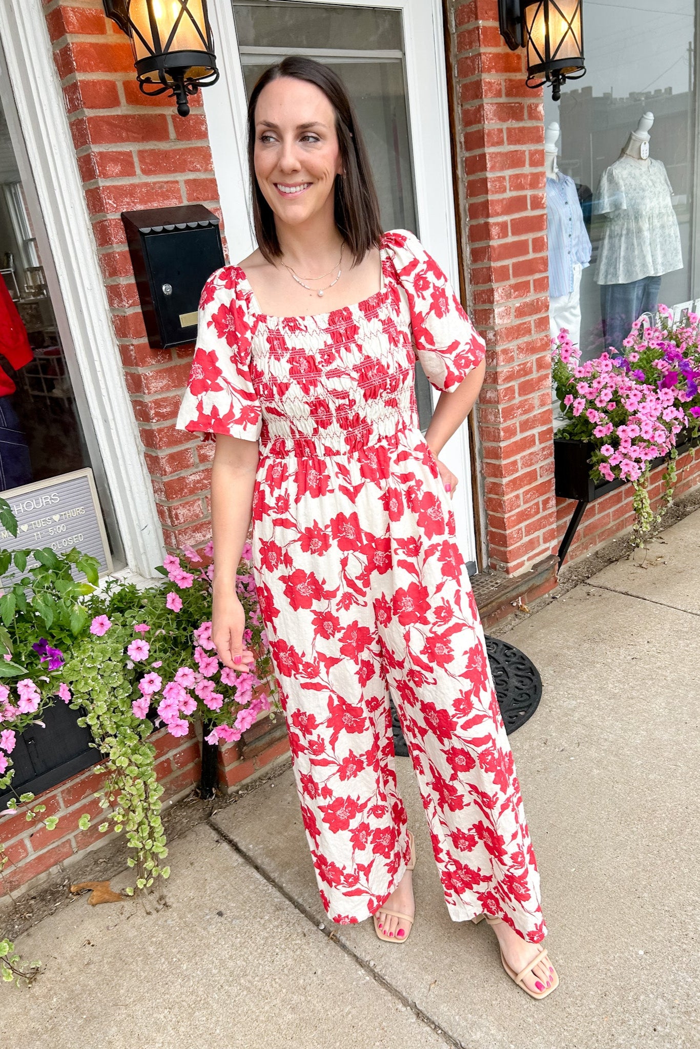 Red and white floral jumpsuit with square neckline. Short sleeved. Wide leg with smocked top. 