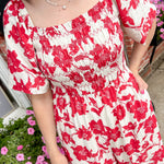 Red and white floral jumpsuit with square neckline. Short sleeved. Wide leg with smocked top. 
