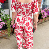 Red and white floral jumpsuit with square neckline. Short sleeved. Wide leg with smocked top. 