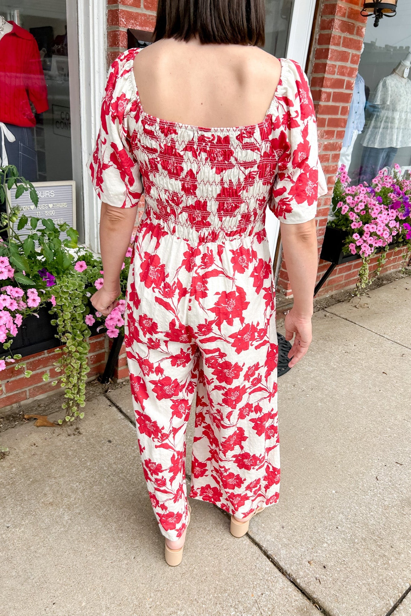 Red and white floral jumpsuit with square neckline. Short sleeved. Wide leg with smocked top. 