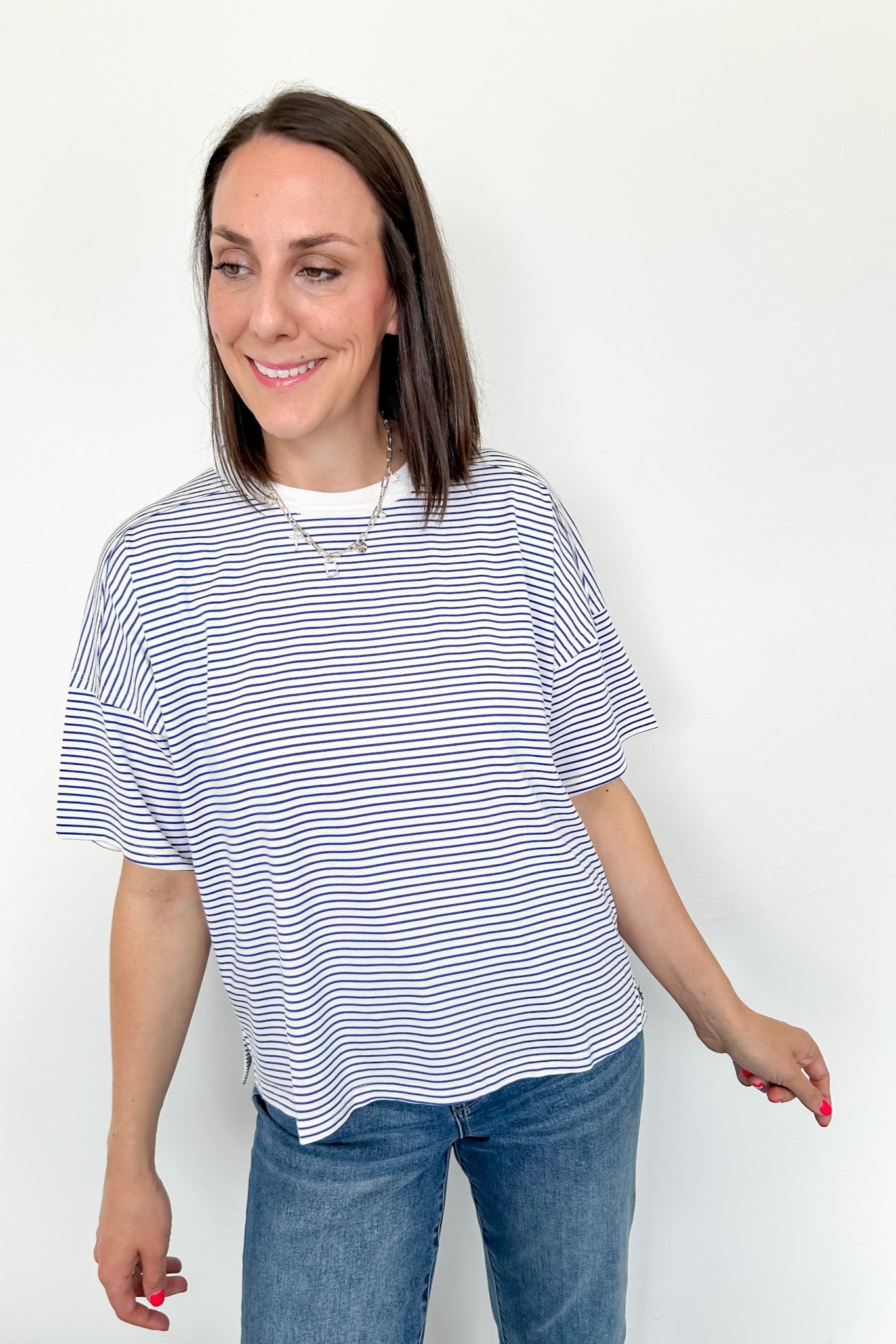 Oversized tee with crew neckline. White and royal blue in color. Striped pattern. 