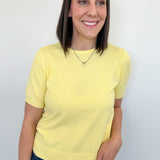 Woman wearing a yellow shirt and blue jeans against a white background