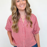 Woman wearing a red and white checkered shirt against a white background