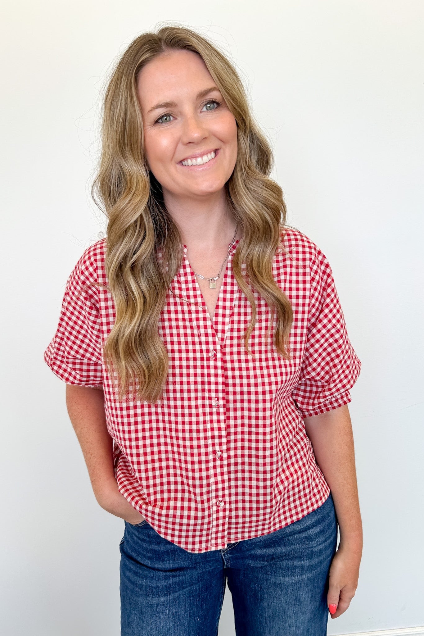 Woman wearing a red and white checkered shirt against a white background