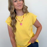 Woman wearing a yellow top and blue jeans against a white background