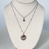 Two necklaces on a mannequin bust against a plain background