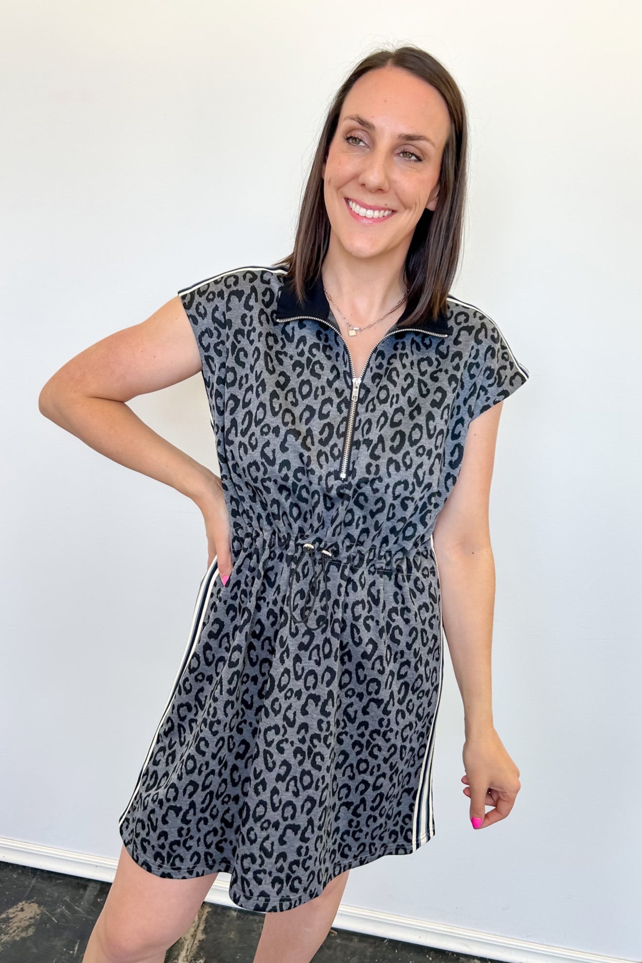 Woman wearing a leopard print dress against a white background