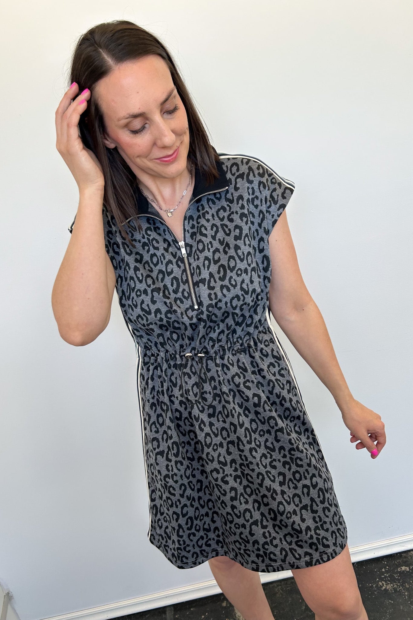 Woman wearing a leopard print dress against a plain background