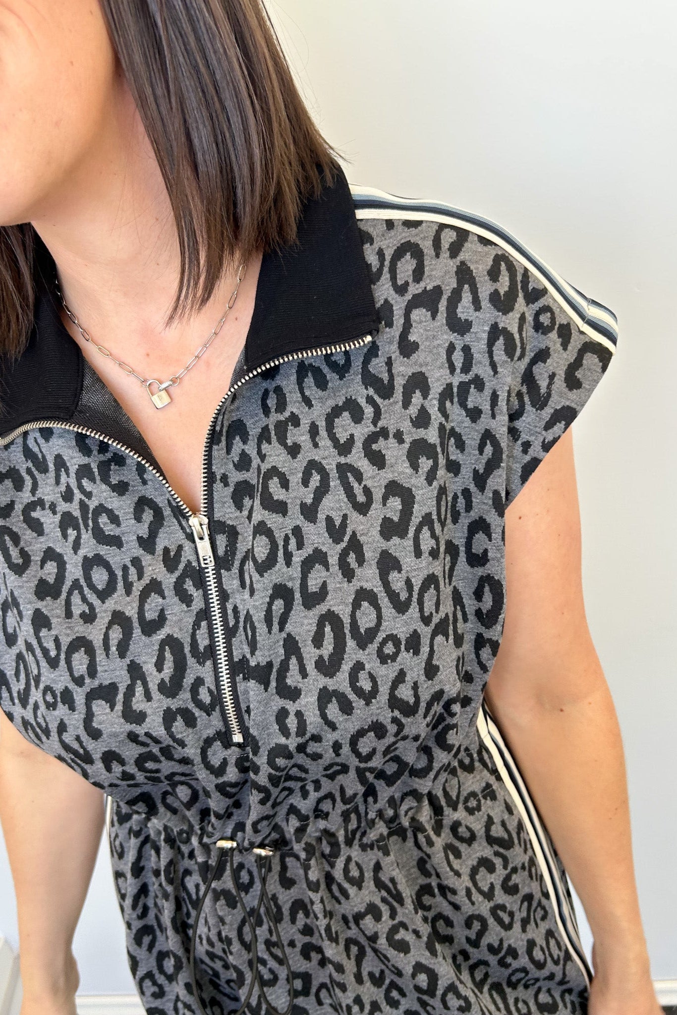 Person wearing a leopard print sleeveless top with black zipper