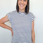 Woman wearing a black and white striped shirt against a plain background