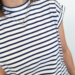 Person wearing a navy and white striped shirt against a plain background