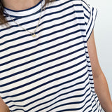 Person wearing a navy and white striped shirt against a plain background