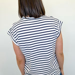 Person wearing a black and white striped shirt against a plain background