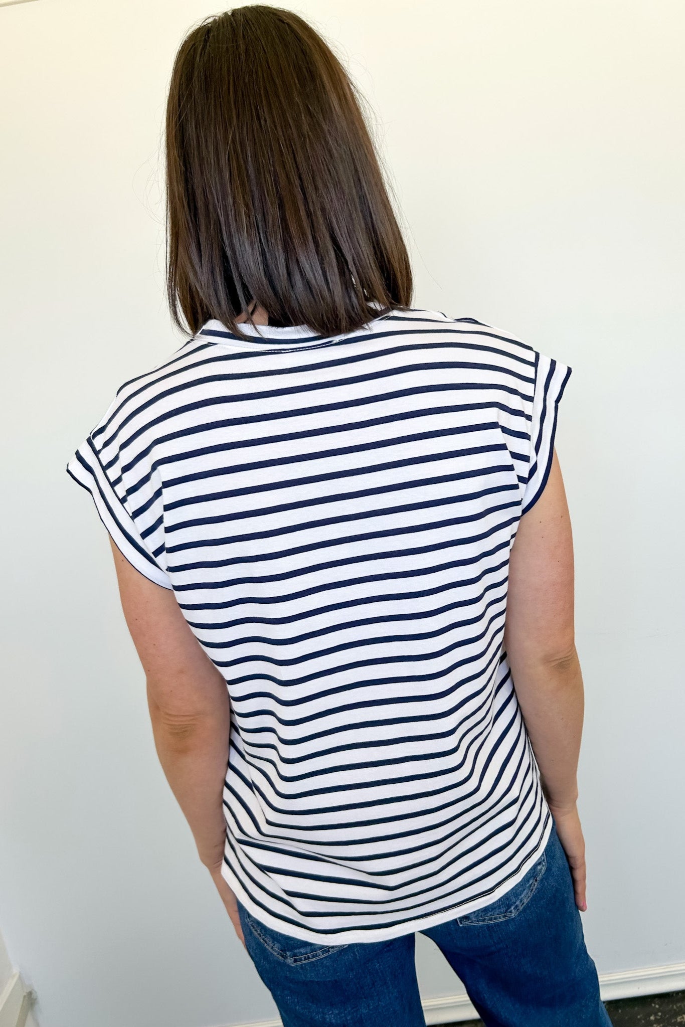 Person wearing a black and white striped shirt against a plain background