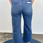 Person wearing blue jeans and a red top on a plain background