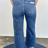 Person wearing blue jeans and a red top on a plain background