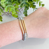 Bracelet on a wrist with a plant in the background