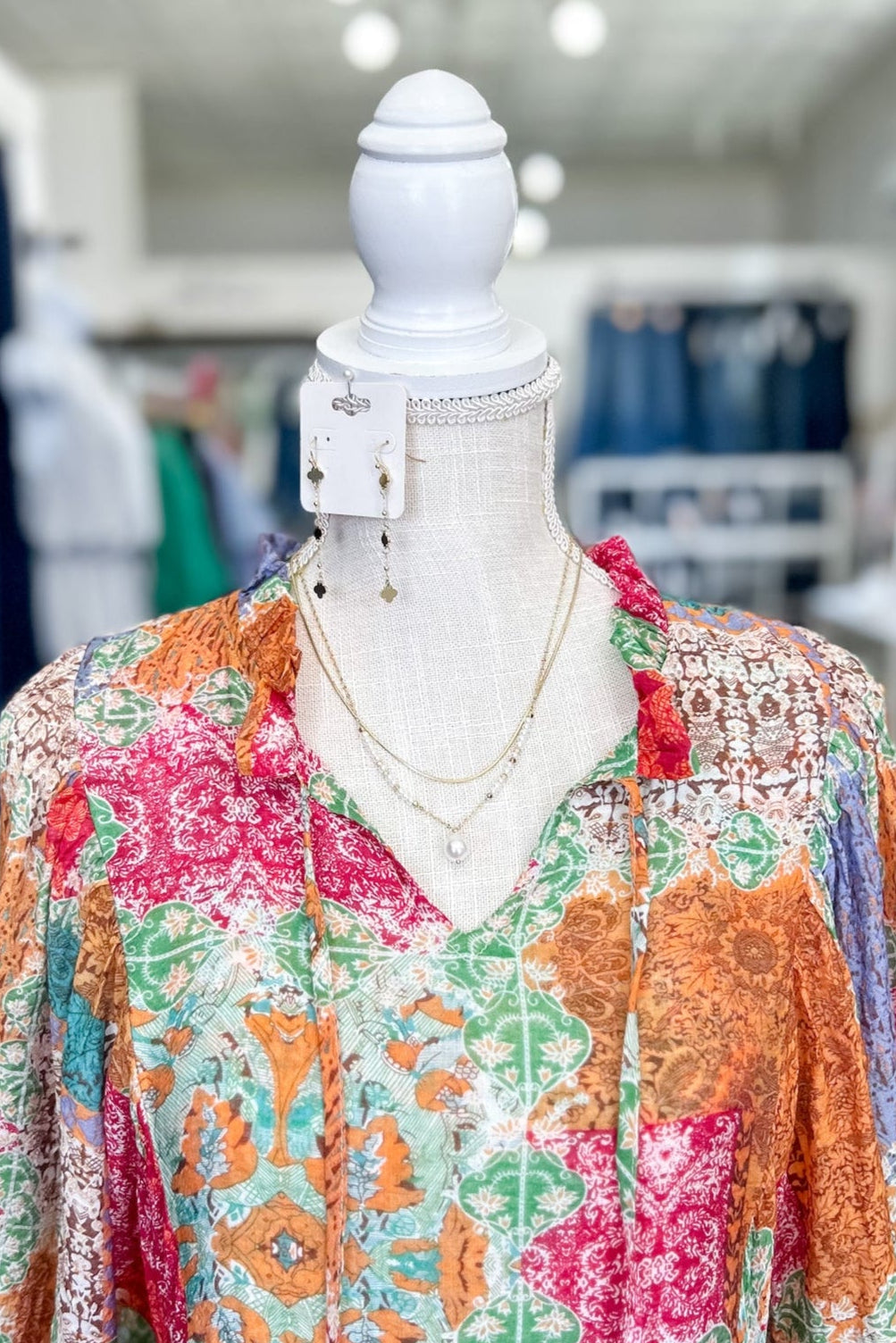 Colorful patterned dress on a mannequin in a store setting