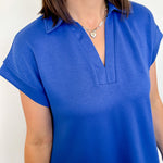 Person wearing a blue short-sleeve top with a white background