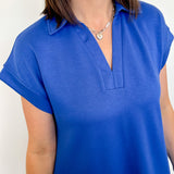 Person wearing a blue short-sleeve top with a white background
